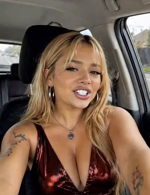 A creator talking to camera from the driver’s seat of a car